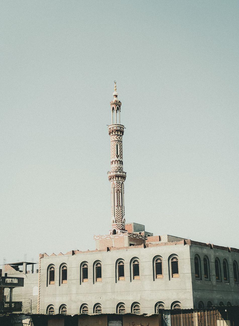 Minaret of a mosque against a pale morning sky