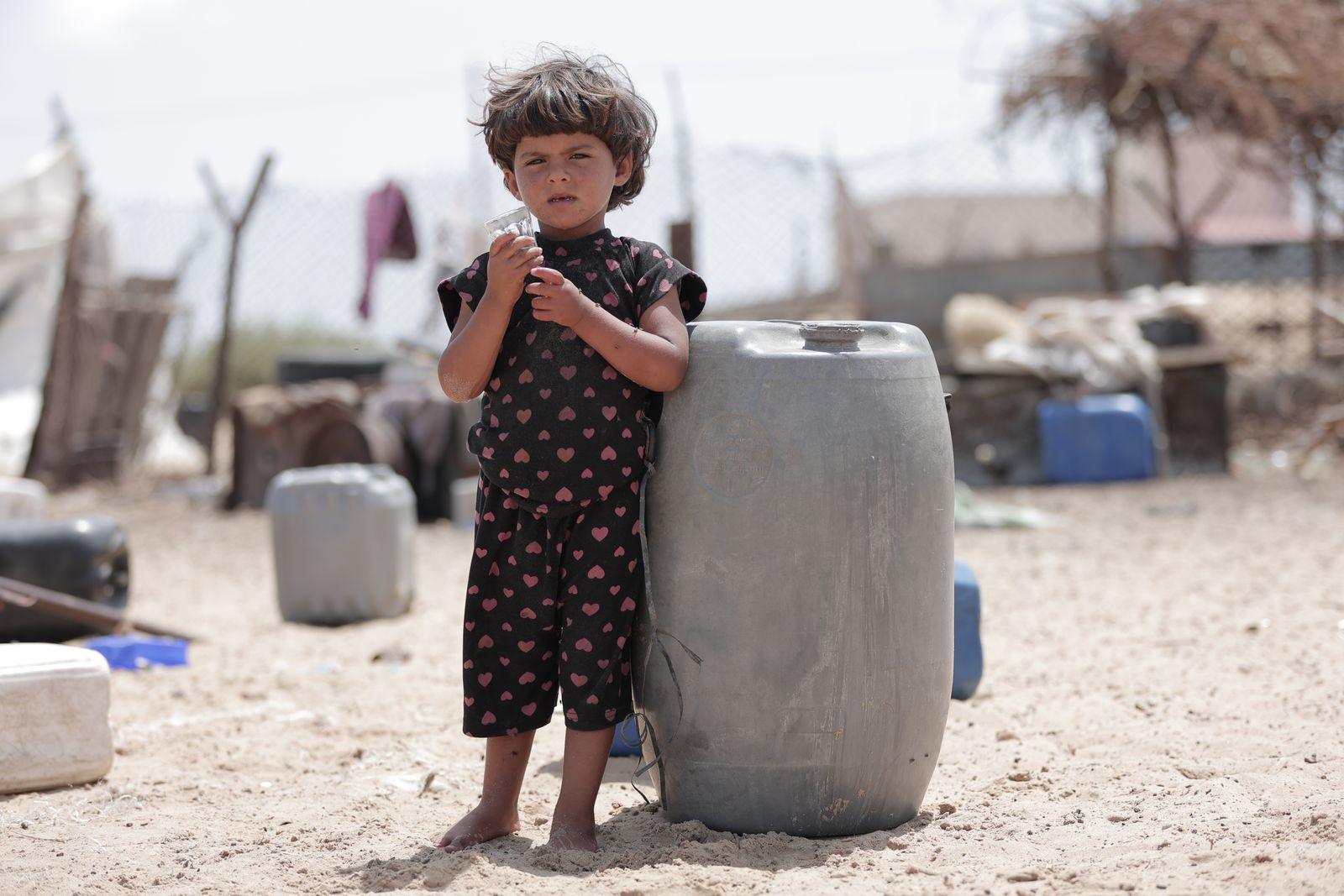 A child in Gaza carrying a water barrel